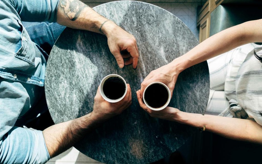 Deux personnes partagent un café autour d'une table, vue de dessus